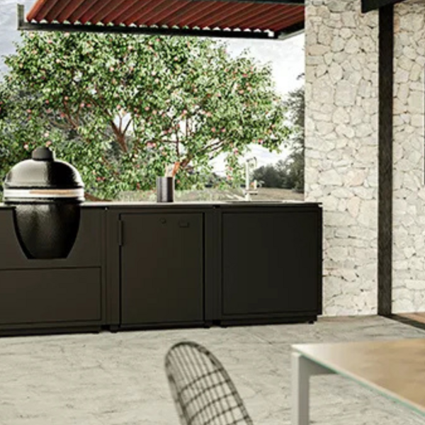 CB Outdoor Kitchen steht auf einer großen Terrasse aus Stein und Bäumen im Hintergrund.