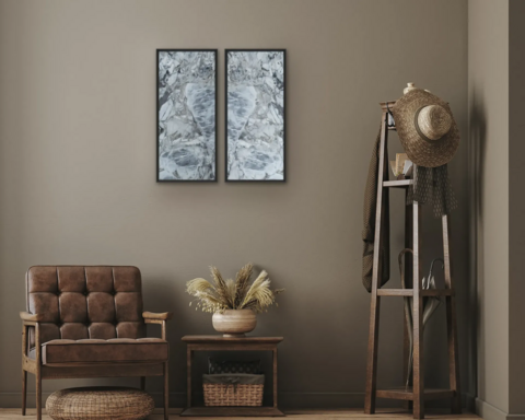 Ein hellblaues Steinbild mit Spiegeleffekt hängt an einer grau-braunen Wand, vor der ein Sessel, ein kleiner Tisch und ein Kleiderständer stehen.