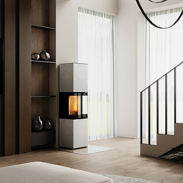 Kamin steht vor einer holzvertäfelten Wand in einem Raum, aus dem eine Treppe hoch führt.