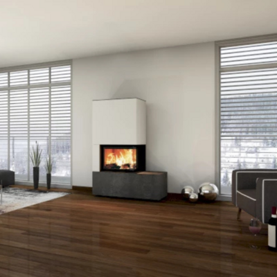 Der neocube Corner Kaminofen steht in einem modernen Wohnzimmer vor einer Wand, die von zwei Fenstern eingeschlossen wird.